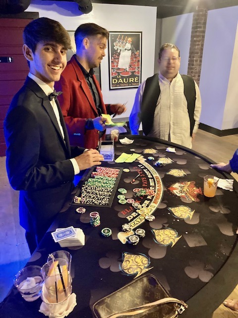 blackjack-dealer-young-party-guests - The Main Event Company Blackjack dealer helping young party guests