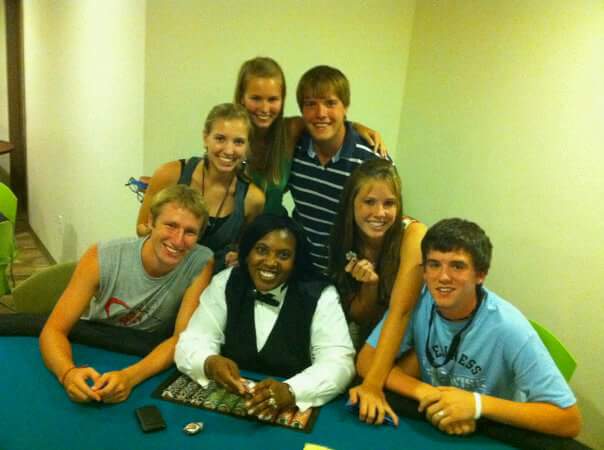 casino-dealer-with-group-young-guests - The Main Event Company A professional casino dealer engaging with event guests