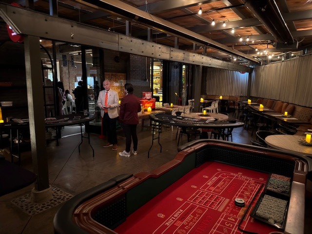 Craps table arranged inside an event venue with exposed ceiling beams