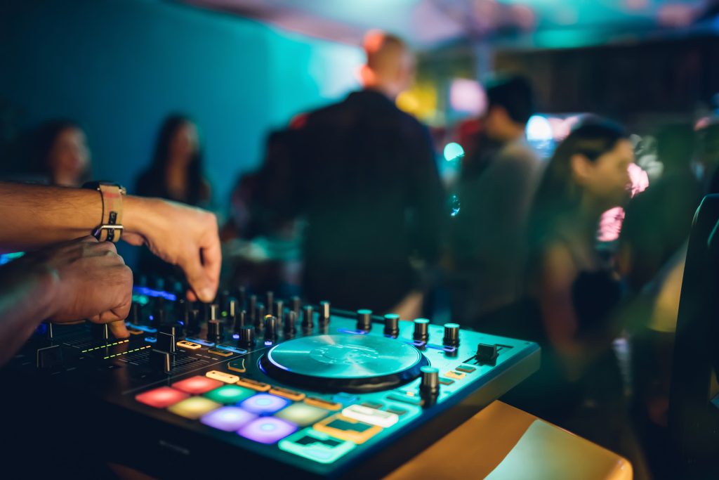 dj-mixing-music-turntable-adobestock-247645673 - The Main Event Company DJ mixing music on a professional sound setup