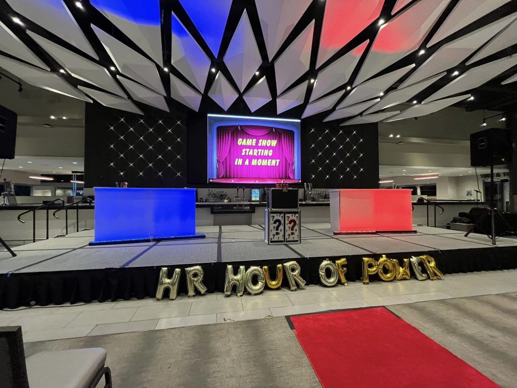 gameshow setup (1) - The Main Event Company Game show stage with illuminated red and blue team podiums and a presentation screen