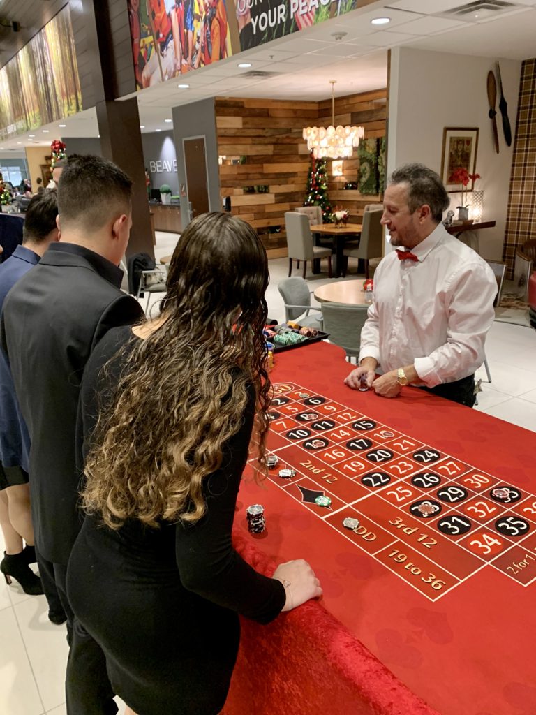 roulette-dealer-red-table-guests - The Main Event Company Roulette dealer and guests at a casino event
